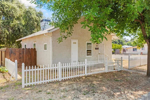 a view of a house with a small yard and wooden fence