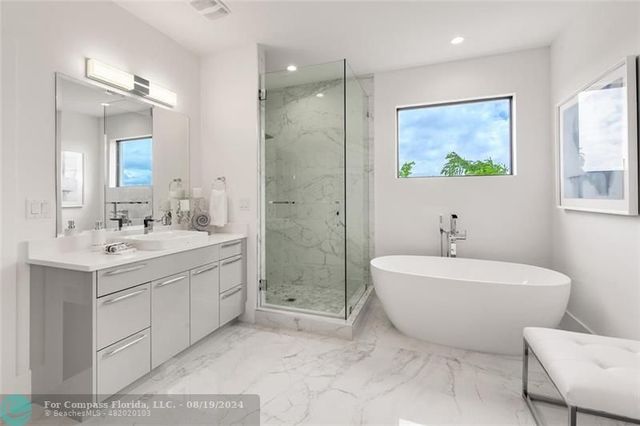 a spacious bathroom with a double vanity sink mirror and bathtub