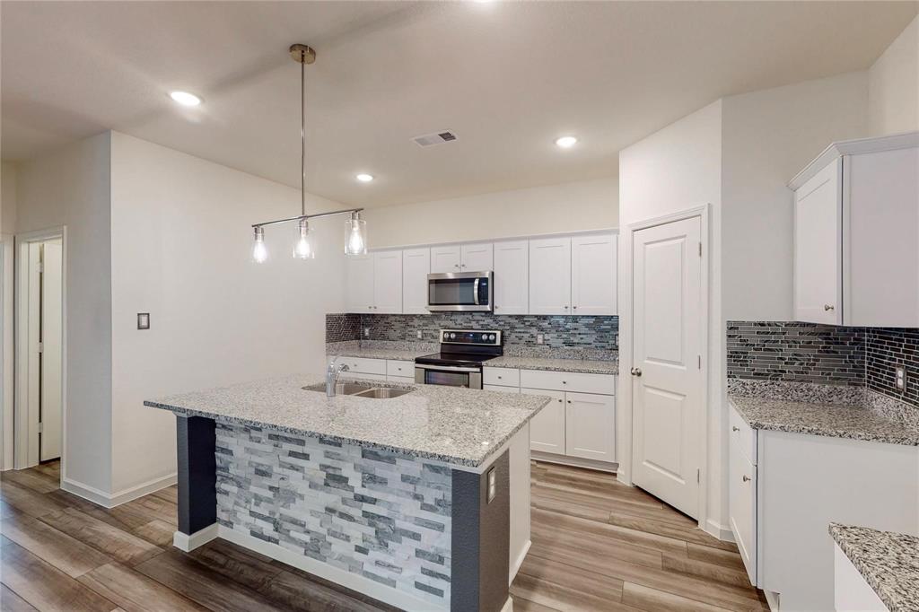 407 Madison Way Princeton, TX 75407 - Photo 15 of 40 Kitchen featuring backsplash, appliances with stainless steel finishes, light wood-style flooring, white cabinets, and recessed lighting