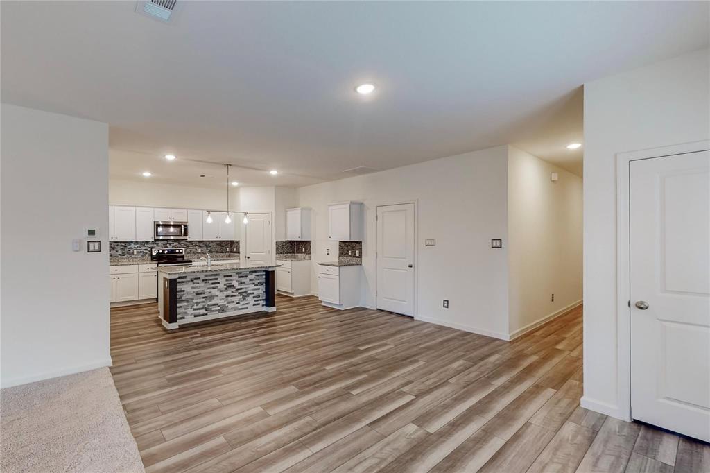 407 Madison Way Princeton, TX 75407 - Photo 38 of 40 Kitchen featuring backsplash, light wood-style flooring, white cabinets, recessed lighting, and open floor plan