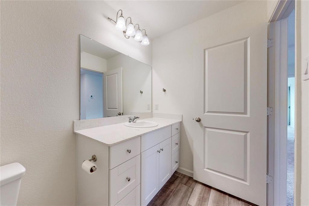 407 Madison Way Princeton, TX 75407 - Photo 7 of 40 Bathroom featuring vanity and wood finished floors