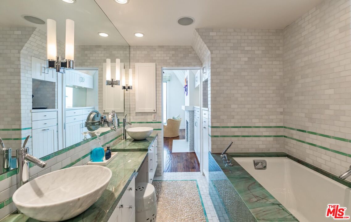23416 Malibu Colony Road Malibu, CA 90265 - Photo 18 of 26 a bathroom with a tub a sink and a wooden floor