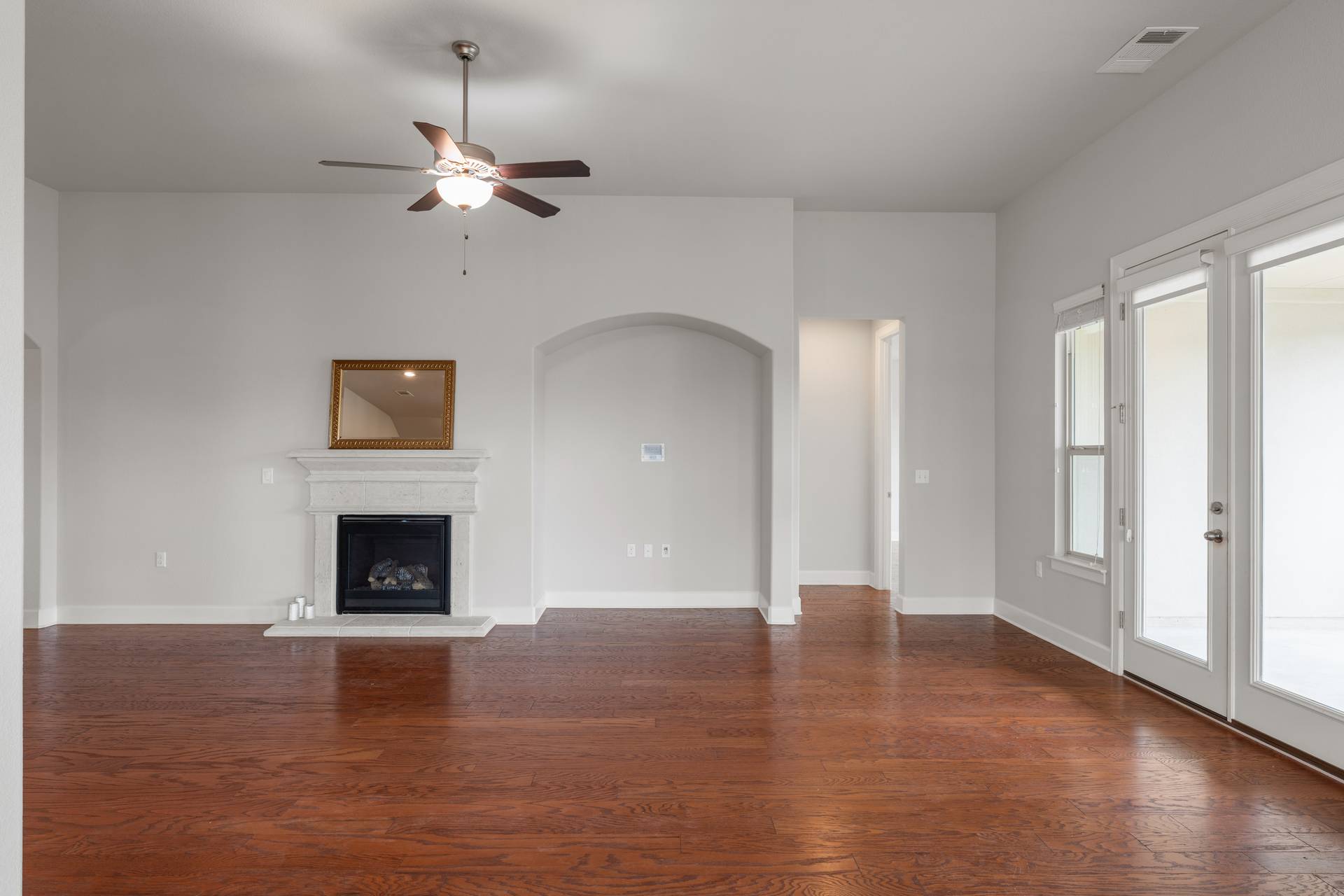 3516 Venezia View Leander, TX 78641 - Photo 7 of 40 living room featuring ceiling fan, a glass covered fireplace, and dark wood finished floors