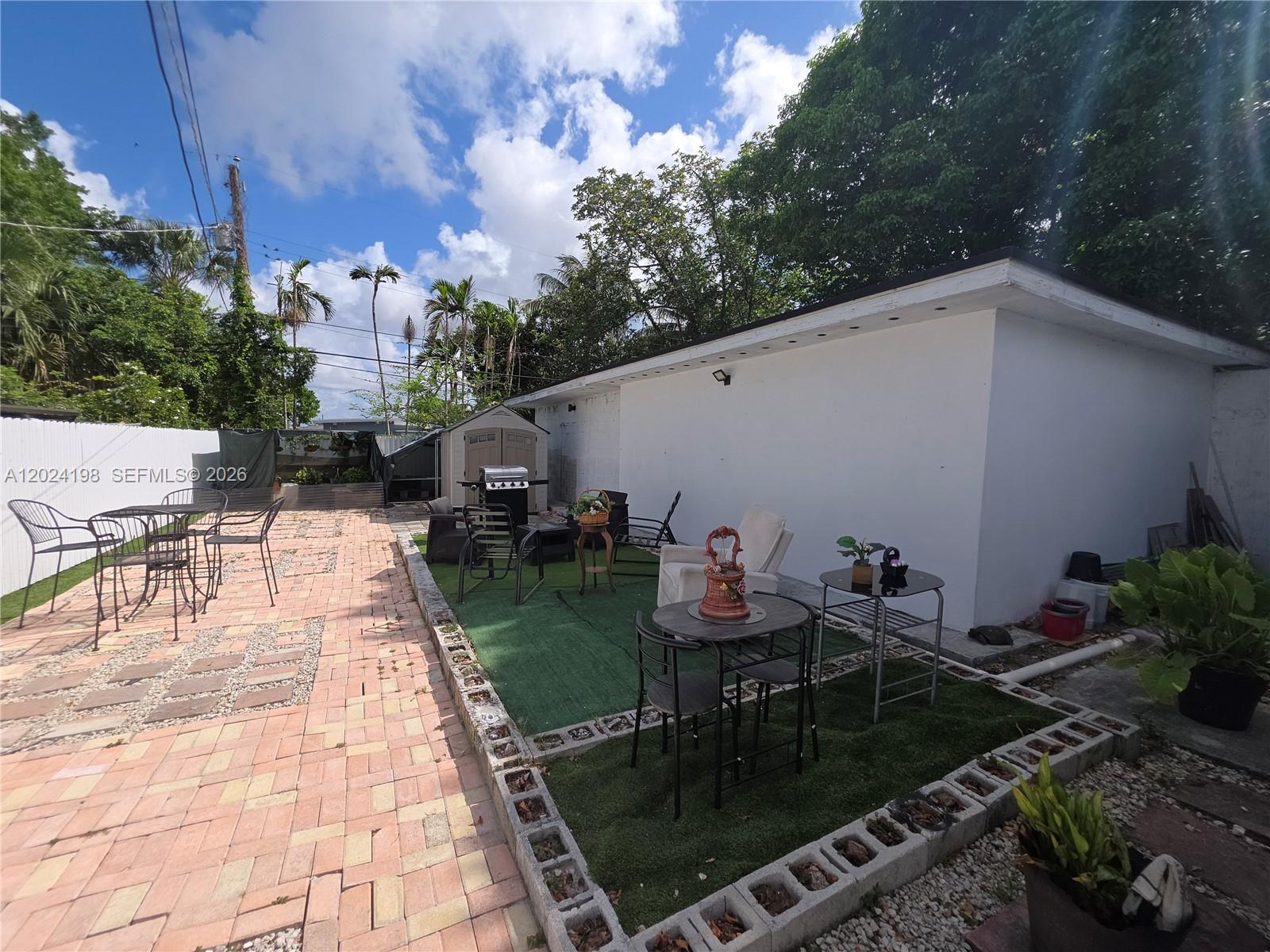 651 East 48th Street Hialeah, FL 33013 - Photo 28 of 52 a backyard of a house with table and chairs