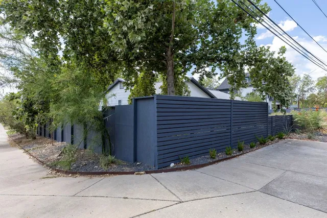 a view of a house with a yard and table and chairs under an umbrella