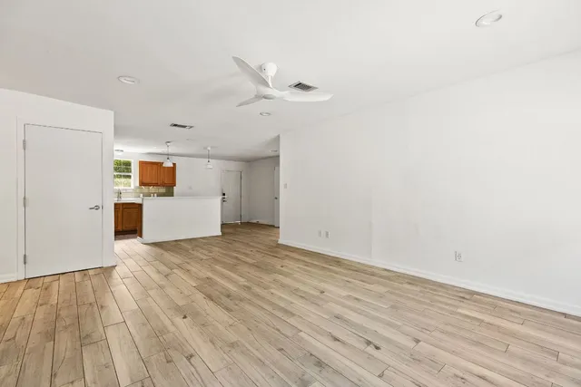 a view of a room with wooden floor and white walls