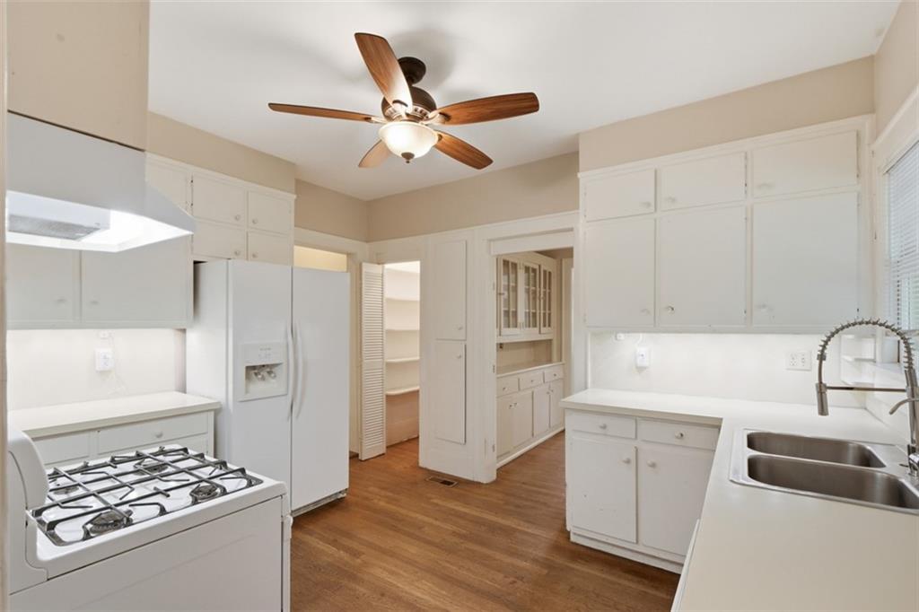 1424 Emory Road Northeast Atlanta, GA 30306 - Photo 16 of 36 a kitchen with stainless steel appliances a sink a stove a refrigerator cabinets and wooden floor