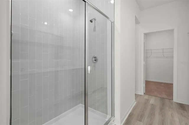 a bathroom with a shower and a glass door