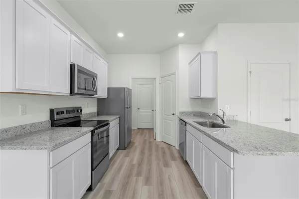 a kitchen with stainless steel appliances granite countertop a stove a sink and a refrigerator