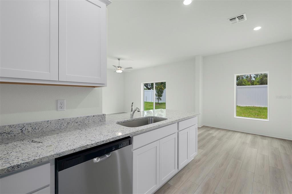13320 Tula Loop Astatula, FL 34705 - Photo 5 of 22 a kitchen with granite countertop a sink and cabinets