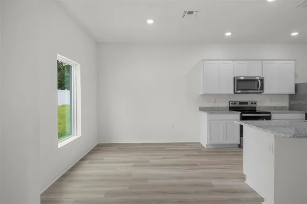 a kitchen with appliances a sink and a window