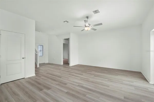 a view of an empty room with wooden floor