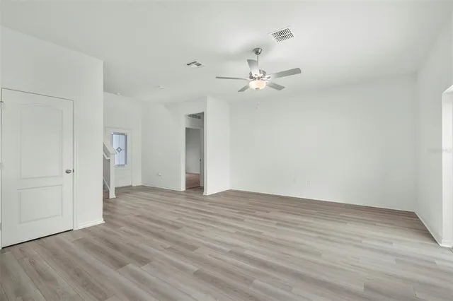 a view of an empty room with wooden floor