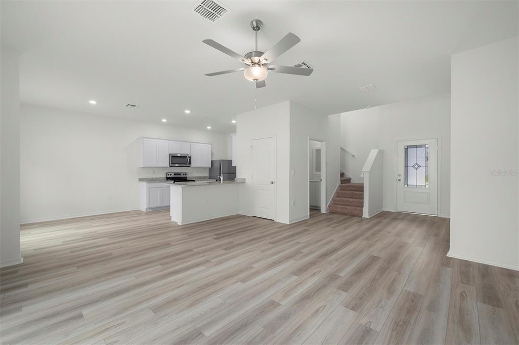 13320 Tula Loop Astatula, FL 34705 - Photo 9 of 22 a view of an empty room with wooden floor and a ceiling fan