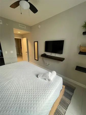 a bedroom with a bed and a flat screen tv