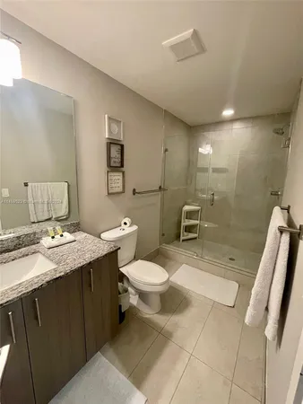 a bathroom with a sink a toilet a mirror and shower