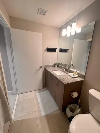 a bathroom with a sink a toilet a mirror and vanity