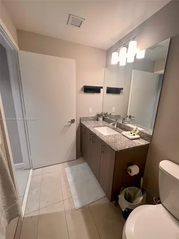 a bathroom with a sink a toilet a mirror and vanity