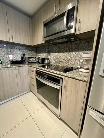 a kitchen with stainless steel appliances granite countertop a stove microwave and sink