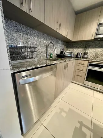 a kitchen with stainless steel appliances granite countertop a sink and a stove
