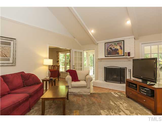 5609 Knollwood Road Raleigh, NC 27609 - Photo 4 of 25 a living room with furniture a flat screen tv and a fireplace