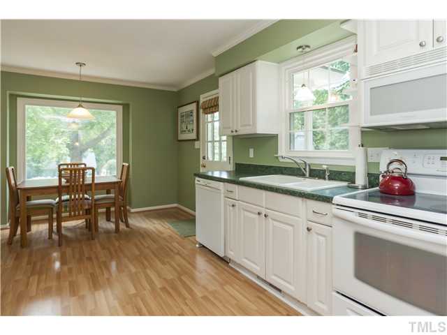 5609 Knollwood Road Raleigh, NC 27609 - Photo 9 of 25 a kitchen with sink cabinets and dining table