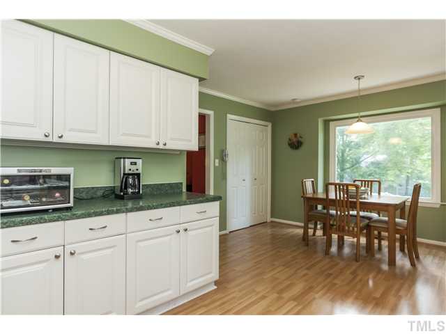 5609 Knollwood Road Raleigh, NC 27609 - Photo 10 of 25 a kitchen with granite countertop a stove a sink a dining table and chairs