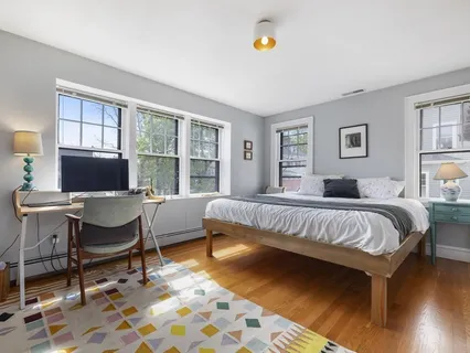 a bedroom with a bed and a table in it with wooden floor