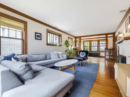 a living room with furniture wooden floor and a large window