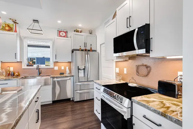 a kitchen with stainless steel appliances a stove microwave and sink