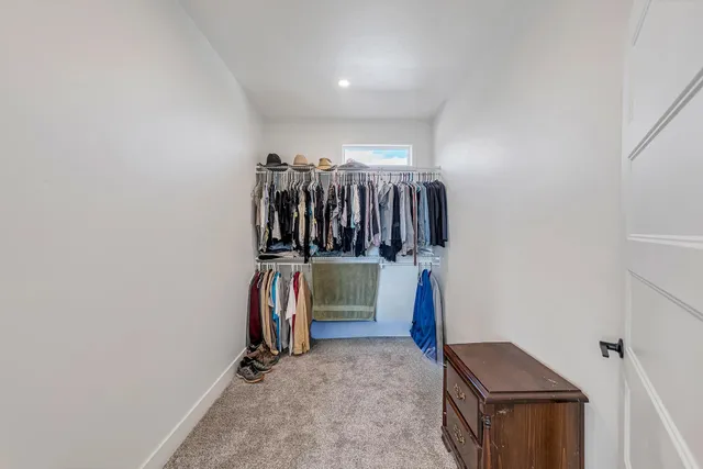 a view of walk in closet with clothes and shoes