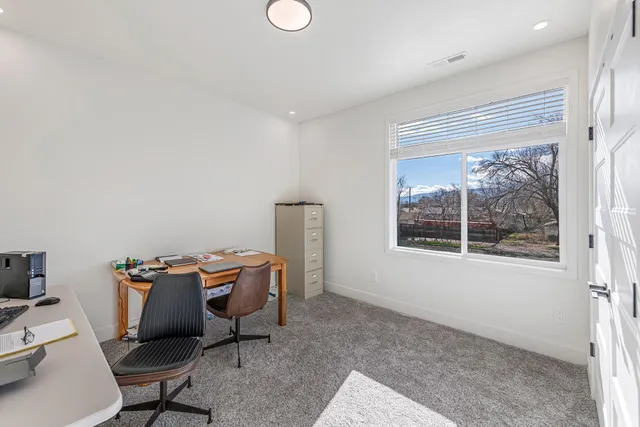 a view of a workspace with furniture and a window