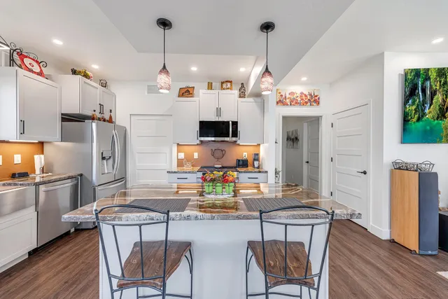 a kitchen with refrigerator and chairs