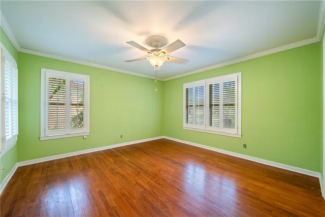 a view of an empty room with window and wooden floor