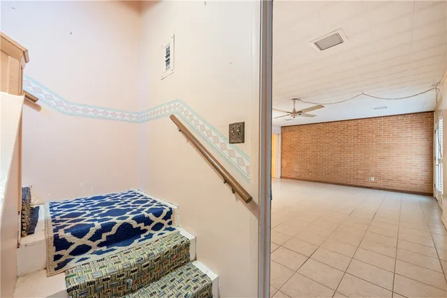 en empty room with windows and ceiling fan