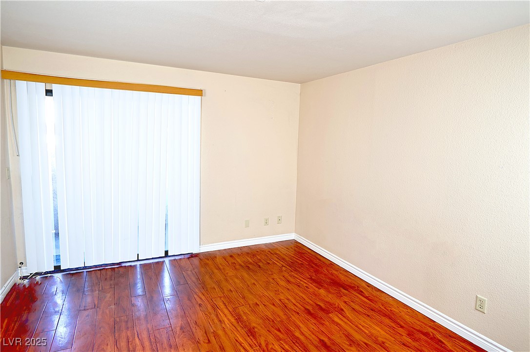 2451 North Rainbow Boulevard, Unit 1020 Las Vegas, NV 89108 - Photo 5 of 14 Unfurnished room featuring hardwood / wood-style flooring and baseboards