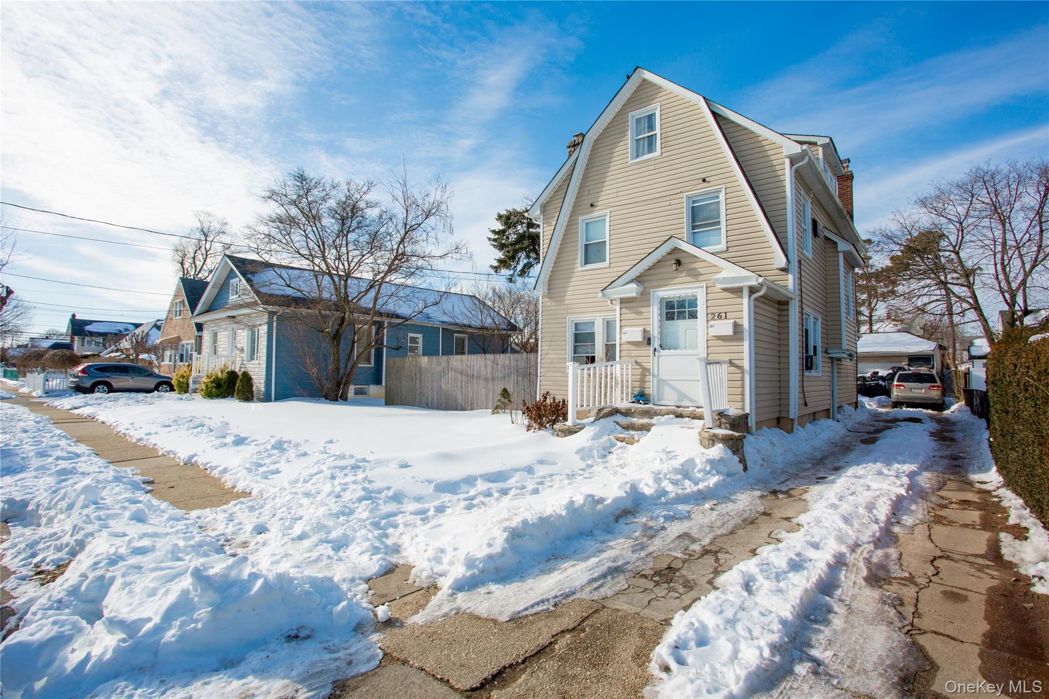 261 Rutland Road Freeport, NY 11520 - Photo 2 of 15 a view of a white house with a yard covered in snow