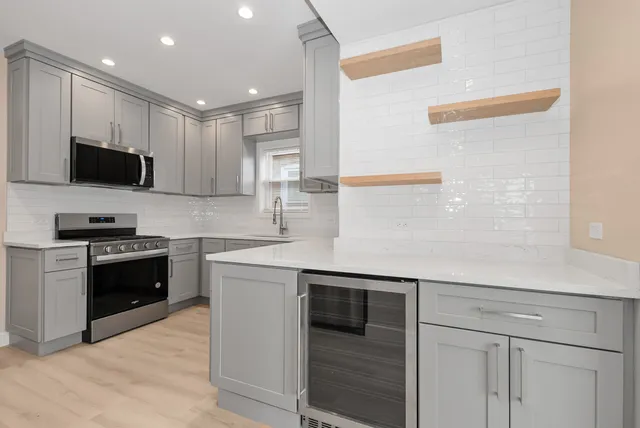 a kitchen with stainless steel appliances kitchen island granite countertop a sink and a stove