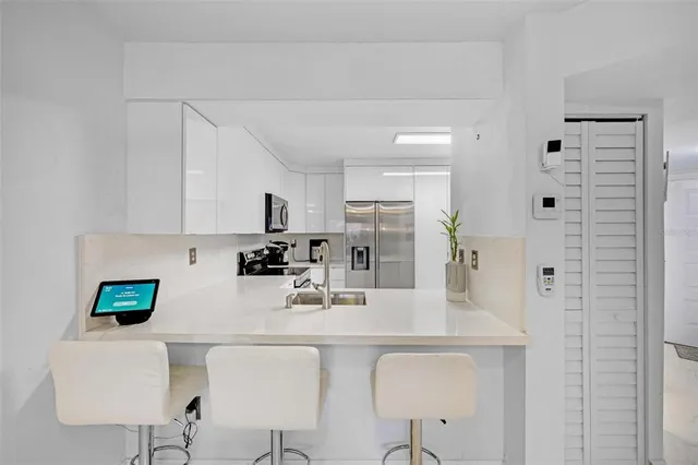 a kitchen with stainless steel appliances a sink a stove a refrigerator and cabinets