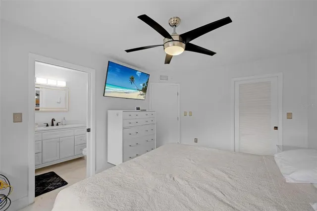 a bedroom with a bed and a tv on the dresser