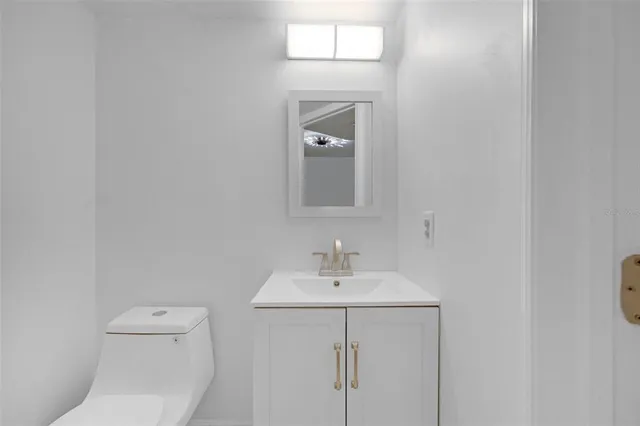 a bathroom with a toilet a sink and mirror