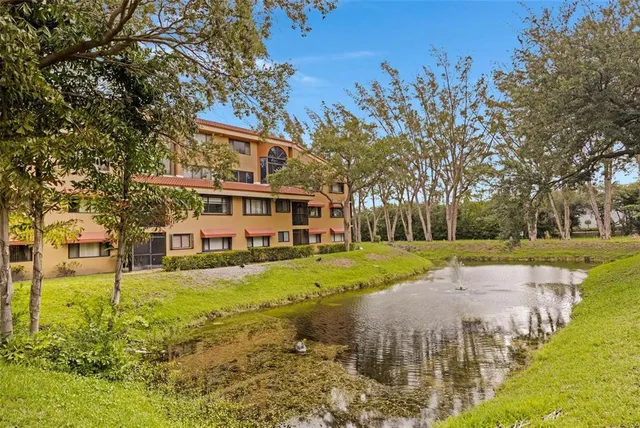 a view of a big house with a big yard and large trees