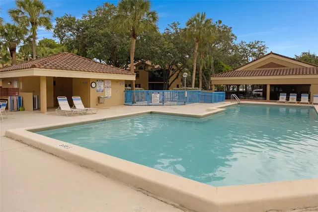 a view of a house with pool and chairs