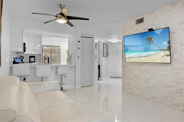 a view of a hallway with wooden floor and a ceiling fan