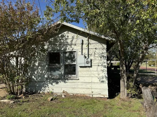 a view of wooden house with a large tree