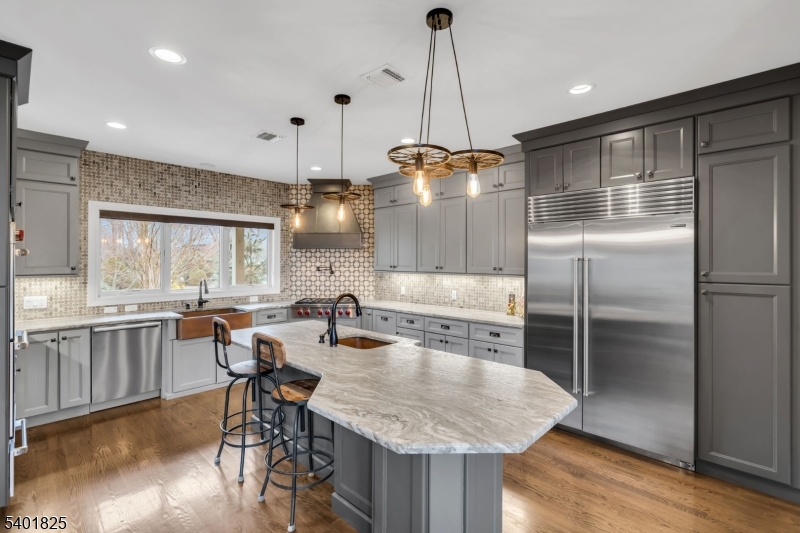 846 Sunset Ridge Bridgewater, NJ 08807 - Photo 18 of 50 a kitchen with kitchen island a refrigerator a stove a dining table and chairs with wooden floor