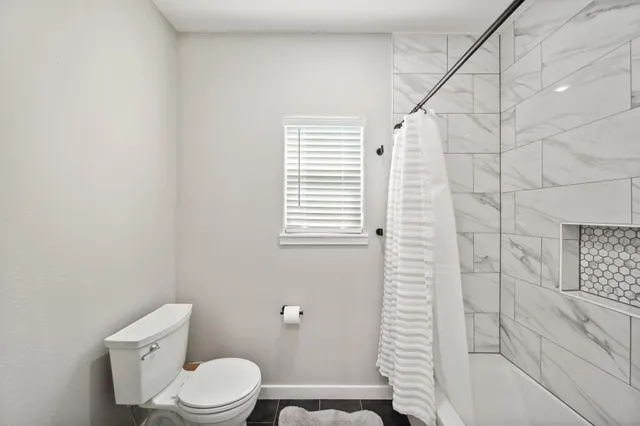a white toilet sitting next to a bath tub