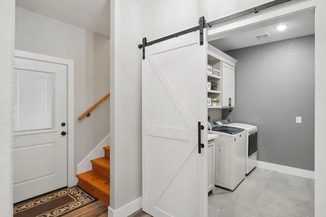 a view of a hallway with stairs and a living room