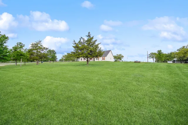 a backyard of a house with lots of green space and lake view