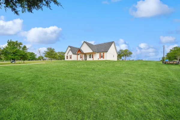 a view of a big yard with a house in the background